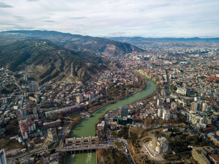 Photo for An aerial view of Tbilisi cityscape with green mountains with blue cloudy sky in Georgia - Royalty Free Image