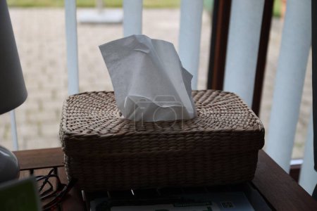 Foto de Una caja de paja para servilletas colocadas sobre una mesa - Imagen libre de derechos