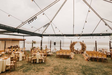 Téléchargez les photos : Une vue des chaises en bois et des décorations sur un jour de mariage au hall extérieur - en image libre de droit