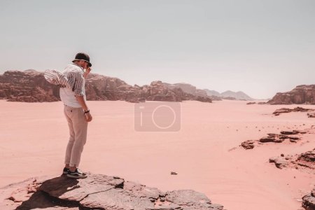 Photo for A Caucasian  man standing on the rocky hill in Wadi rum, Jordan - Royalty Free Image