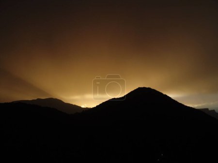 Photo for A scenic view of silhouettes of mountains at sunset in the evening in a rural area - Royalty Free Image