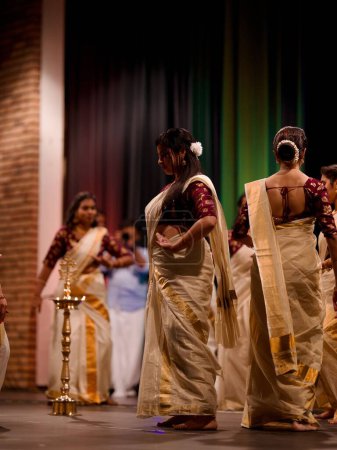Téléchargez les photos : Belles filles indiennes en robes traditionnelles exécutant une danse de bienvenue pendant le festival Onam - en image libre de droit