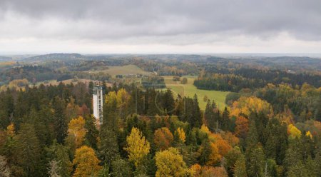 Photo for A drone shot of the Suur Munamagi Tower in Haanja, Estonia, surrounded by autumn forest - Royalty Free Image