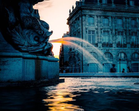 Photo for A scenic fountain with a traditional old building in the background in the evening - Royalty Free Image