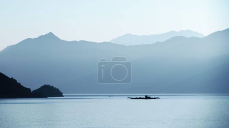 Téléchargez les photos : Vue d'un lac et d'une montagne couverts de brouillard à l'aube - en image libre de droit