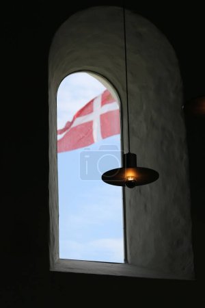 Téléchargez les photos : Plan vertical d'une lampe sur le fond d'une fenêtre et du drapeau suisse - en image libre de droit