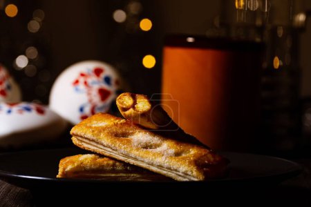 Photo for A closeup of puff pastry on a table with bokeh lights in the background - Royalty Free Image