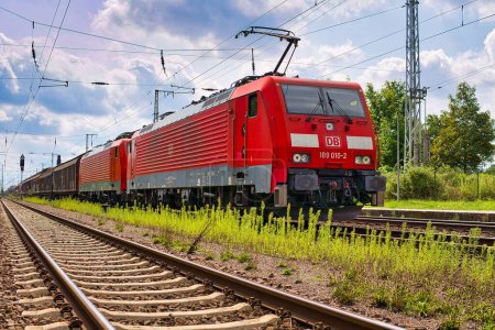 Téléchargez les photos : Une image d'un train lors d'une belle journée ensoleillée entourée d'herbe et d'arbres à Priort, en Allemagne - en image libre de droit