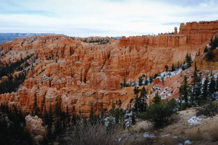 Photo for The stone formation mountain in Bryce Canyon National Park with bushes and cloudy sky, Utah, USA - Royalty Free Image