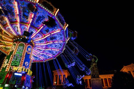 Photo for A low-angle shot of an illuminated ride in the amusement park in Munich on the Oktoberfest festival in the night - Royalty Free Image