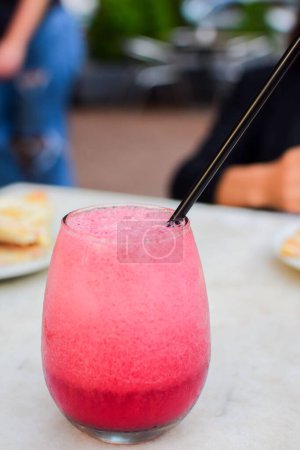 Téléchargez les photos : Un gros plan vertical d'un verre de smoothie rose et une paille noire dedans - en image libre de droit
