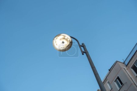 Foto de Un tiro de ángulo bajo de una lámpara de calle bajo un cielo azul claro - Imagen libre de derechos
