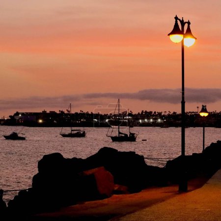 Téléchargez les photos : Une vue panoramique de bateaux dans la mer calme au coucher du soleil - en image libre de droit