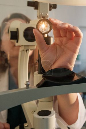 Téléchargez les photos : Portrait vertical d'une ophtalmologiste dans sa salle de consultation - en image libre de droit