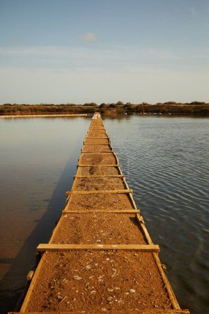 Téléchargez les photos : Un plan vertical d'une barrière de sol avec des constructions en bois dans le lac pour l'extraction du sel - en image libre de droit