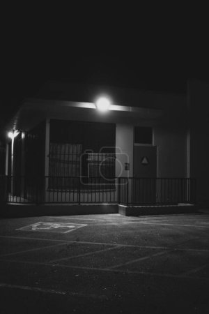 Foto de Una gasolinera por la noche sin nadie allí y una luz brillante iluminando la calle oscura - Imagen libre de derechos