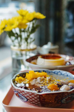 Photo for A vertical shot of Chinese desserts with flowers behind in a beautiful plate - Royalty Free Image