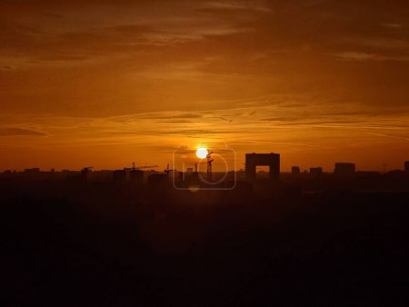 Téléchargez les photos : Une belle silhouette de bâtiments et de grues à Amsterdam lors d'un coucher de soleil orange - en image libre de droit