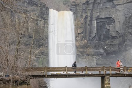 Photo for Ulysses, NY USA March 19, 2022 People standing on bridge taking in view of the waterfalls at Taughannock Falls State Park near Ithaca NY. - Royalty Free Image
