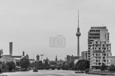 A landscape shot of the construction across the river in Berlin, Germany under the cloudy sky