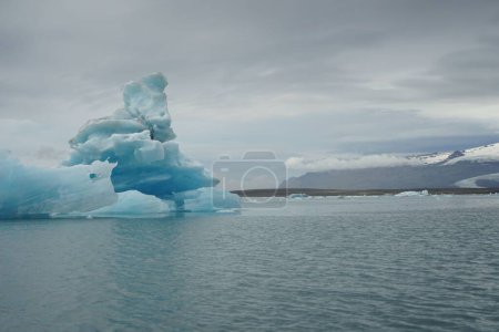 Téléchargez les photos : Grand iceberg bleu flottant à la surface du lac glaciaire de Jokulsarlon, Islande - en image libre de droit
