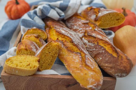 Photo for A closeup of a homemade pumpkin baguette with pumpkins in the background - Royalty Free Image