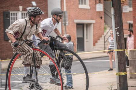 Téléchargez les photos : Deux coureurs courent sur leur vélo penny farthing au centre-ville - la Clustered Spires High Wheel Race 2022 - en image libre de droit