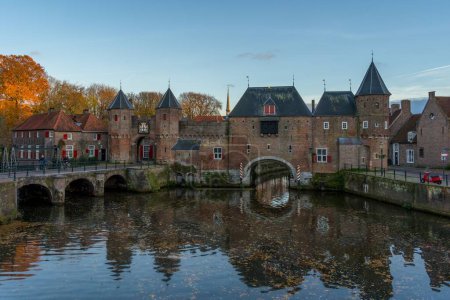 Photo for The medieval gate Koppelpoorti in the Dutch city of Amersfoort beside a still river in Netherlands - Royalty Free Image