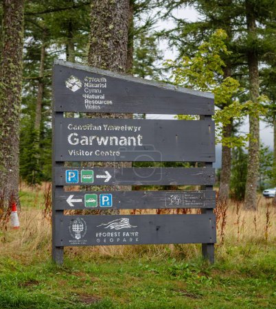 Photo for A vertical shot of a visitor center sign at Garwnant in the Brecon Beacons in the woods - Royalty Free Image