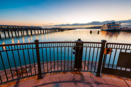Téléchargez les photos : Une vue paysage du long pont et grand bateau au port de San Francisco, Californie au coucher du soleil - en image libre de droit