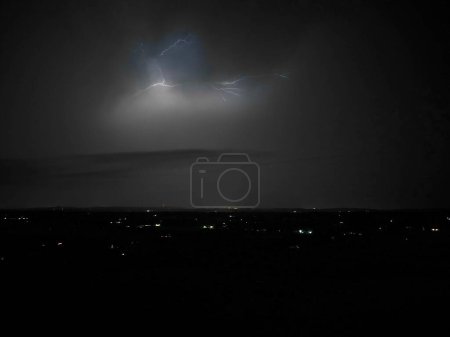 Foto de Una toma a escala de grises de la tormenta sobre la ciudad por la noche - Imagen libre de derechos