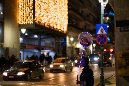 Téléchargez les photos : Femme avec ballon festif dans la rue la nuit - en image libre de droit