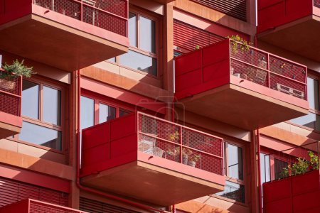 Foto de Un moderno edificio residencial rojo con balcones - Imagen libre de derechos