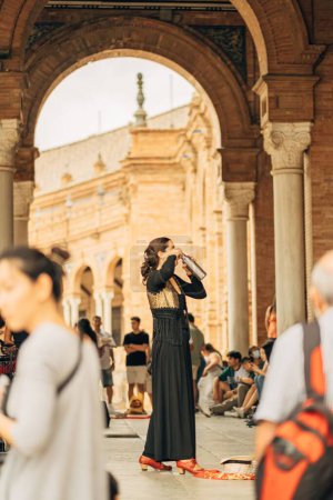 Photo for A vertical shot of a woman near Spain Square in Seville, Spain drinking water from a bottle - Royalty Free Image