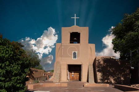 Foto de El exterior del edificio de adobe de la Capilla de San Miguel bajo el cielo azul de Santa Fe - Imagen libre de derechos
