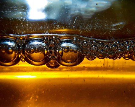 Foto de Un primer plano de burbujas de aire de diferentes tamaños en un agua, aceite caliente - Imagen libre de derechos