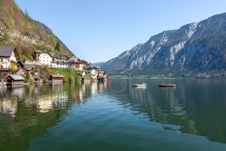 Téléchargez les photos : Bord du lac panoramique avec quelques bateaux flottants à Hallstatt, Autriche - en image libre de droit