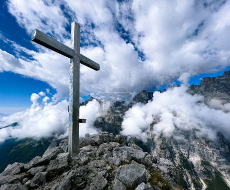 Téléchargez les photos : Une croix sur un pic rocheux par temps nuageux - en image libre de droit