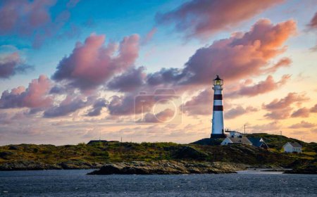 Téléchargez les photos : Un phare avec un ciel couchant sur le fond - en image libre de droit