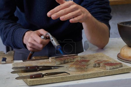 Téléchargez les photos : Un ouvrier chauffe un morceau de métal dans un atelier - en image libre de droit