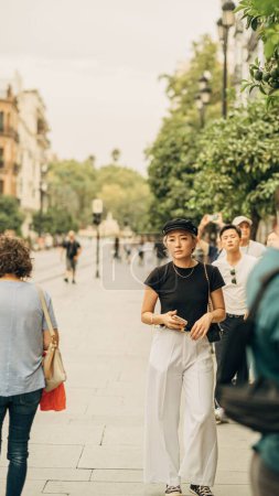 Téléchargez les photos : Plan vertical d'une femme asiatique marchant dans une rue de Séville, Espagne - en image libre de droit