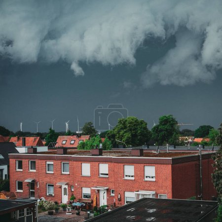 Téléchargez les photos : Une vue de dessus des bâtiments en résine semblables, des maisons avec bouleau rouge capturées sous un ciel gris sombre - en image libre de droit