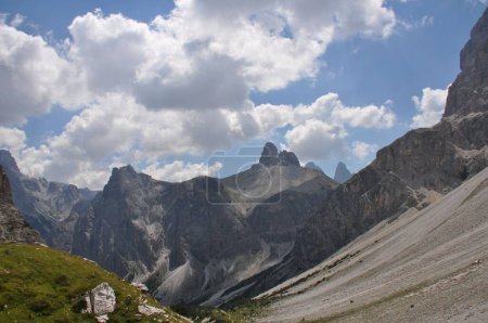Foto de Las montañas dentadas y secas con picos escarpados y pendientes agudas, nubes blancas en el cielo azul - Imagen libre de derechos