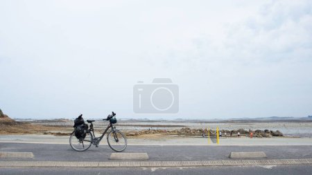 Téléchargez les photos : Un vélo stationné sur une route côtière à Saint Pol de Leon, Bretagne française - en image libre de droit