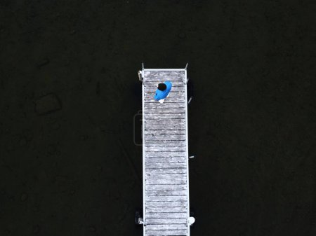 Téléchargez les photos : Vue aérienne d'un homme en pull bleu debout sur un quai sur le lac Québec - en image libre de droit