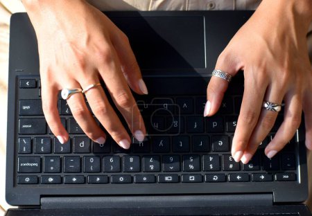 Téléchargez les photos : Gros plan d'une jeune femme travaillant sur son ordinateur portable avec un écran vide pendant la journée - en image libre de droit