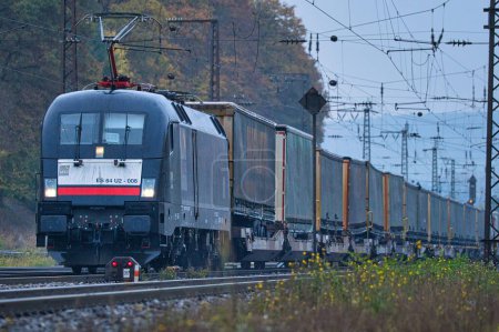 Téléchargez les photos : Une locomotive Siemens TAURUS de classe 182 (182 508) de MRCE conduit un train de marchandises avec des semi-remorques à travers Gemuenden. - en image libre de droit