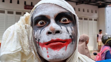 Foto de Un primer plano de una persona mirando a la cámara con maquillaje aterrador en un festival callejero, Indonesia - Imagen libre de derechos