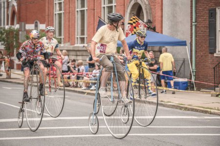 Photo for Riders racing on their penny-farthing bicycle downtown - the Clustered Spires High Wheel Race 2022 - Royalty Free Image