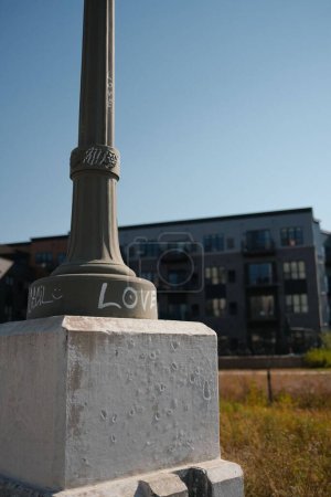 Photo for A vertical of a street column with the word LOVE written on it - Royalty Free Image